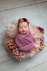 Newborn Baby Sleeping in Floral Basket © Svetlana