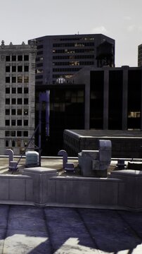A rooftop with various structures and materials. The background includes tall buildings, and the sky shows hints of sunset light.
