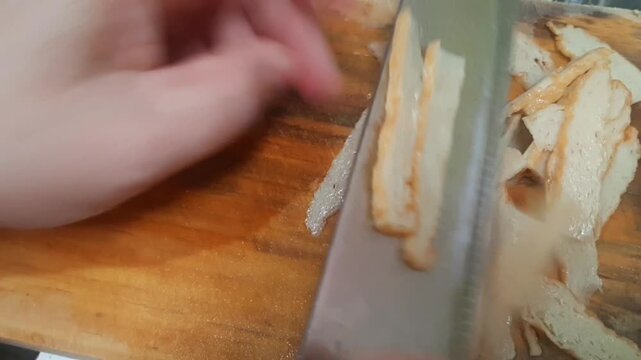 Close-up of slicing fish balls on a cutting board as part of preparing cooking ingredients.