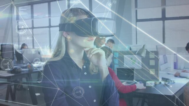 Woman lifting hand in office tracing network nodes for data analysis using holographic VR overlay