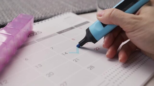 hand marks calendar for pill intake, medication schedule planning and adherence tracking