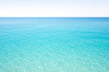 Obraz premium Tranquil clear blue ocean surface under bright sunny sky