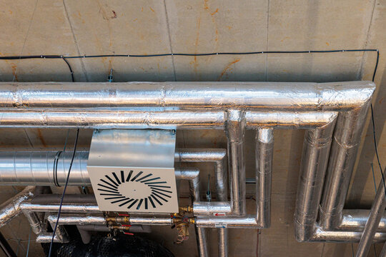 Insulated HVAC Ductwork and Piping on Industrial Concrete Ceiling in Commercial Building