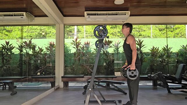 homem faz exerc&iacute;cios fis&iacute;cos em academia 