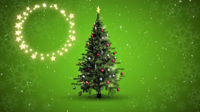 Decorative shining star lights against snowflakes falling over christmas tree on green background