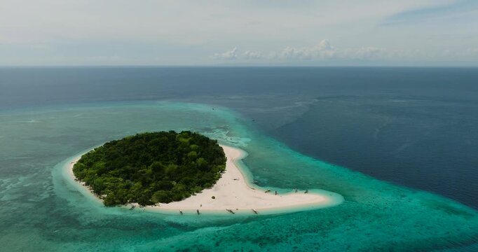 Mantigue Island with sandbar. Greenish water and corals. Camiguin, Philippines.