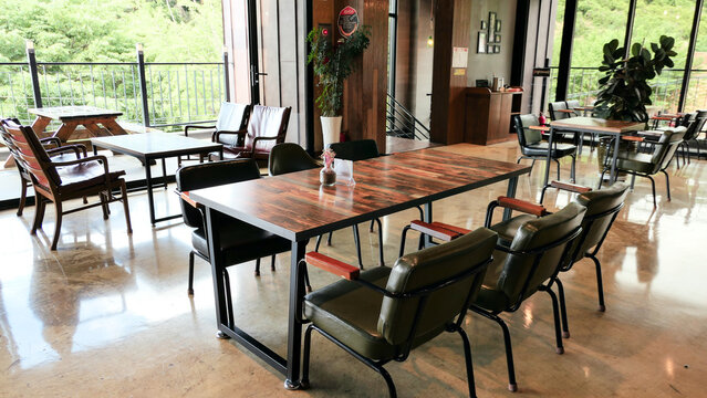 우드 테이블과 가죽 의자가 있는 현대적인 카페 라운지 인테리어 풍경