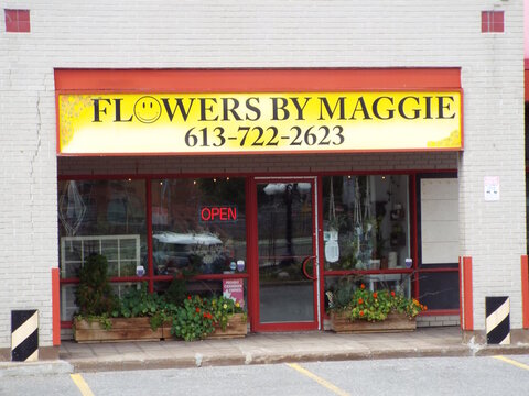 Ottawa, Ontario, Canada-July 23, 2025: The "Kiki Barber Shop" storefront features a red-framed entrance, professional signage, and traditional barber poles for grooming services at 911 Richmond Rd.

