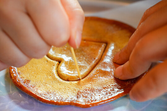 Child's Hands Carefully Carving Heart Shaped Dalgona Candy with a Toothpick in Korea