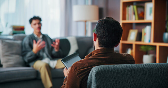 Man, psychology and consultation with therapist for mental health, advice and trauma recovery. Client, therapy and counseling session with notes for assessment, listen or help with ptsd in office