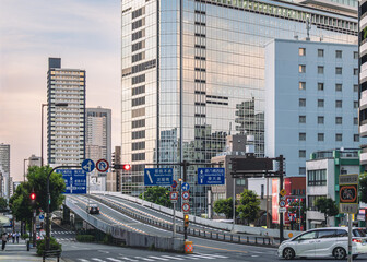 Fototapeta premium 夕日に照らされる都市の道路とビル