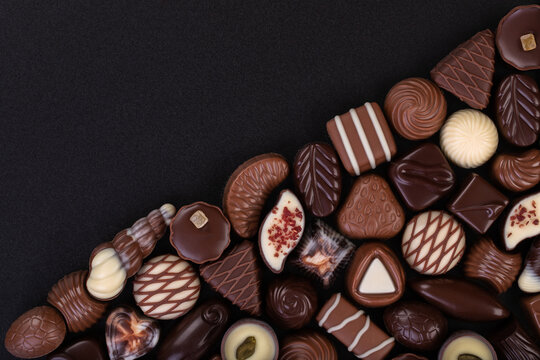 mix chocolate candy on chalkboard, dessert food background.