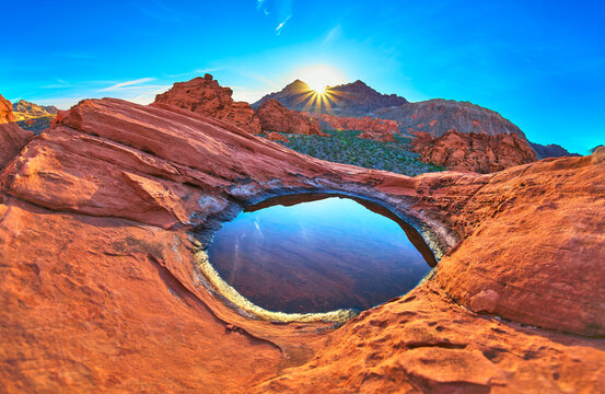 Redstone Dune Desert Tinaja with Sunrise Sunburst and Water Reflection in Nevada