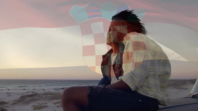 Animation of flag of croatia over diverse couple on car at sunset beach