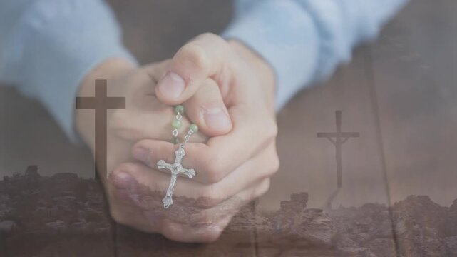 Holding rosary, hands praying over cross animation on rocky landscape