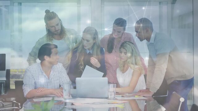 Female presenter holding printed sheet sparking business team reviewing project plans with overlay