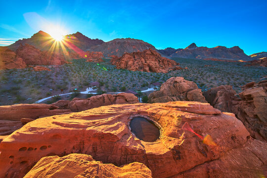 Redstone Dune Sunrise Sunburst with Water Filled Desert Tinaja and Rugged Landscape