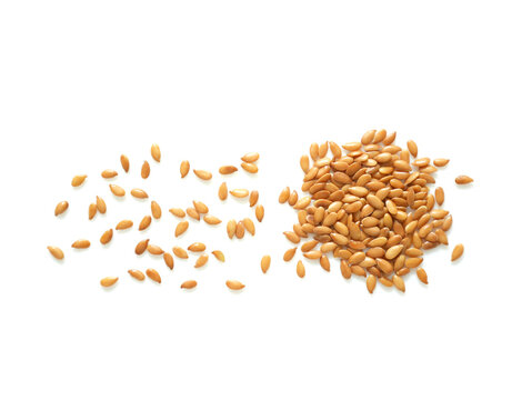Spreading golden roasted flaxseeds isolated on white background