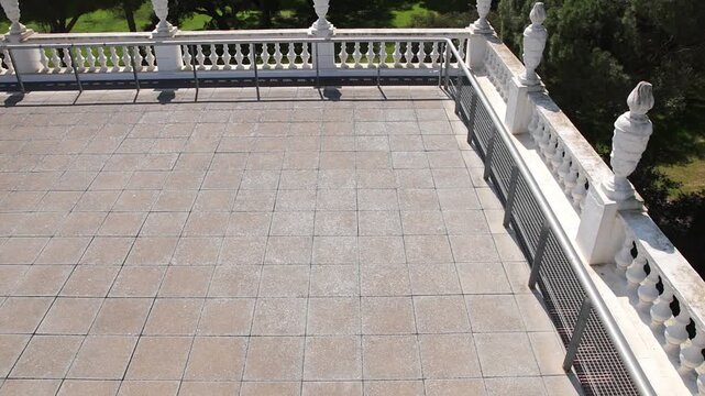 High angle view of a woman walking across the white terrace of Acebron Palace, overlooking the vast pine forests of Donana in Almonte, Huelva.