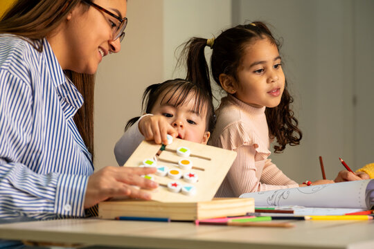 Teacher and diverse children engaging in educational activity at kindergarten classroom