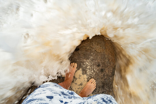 Waves crash around a rock on Sint Maarten island in the Caribbean Sea.