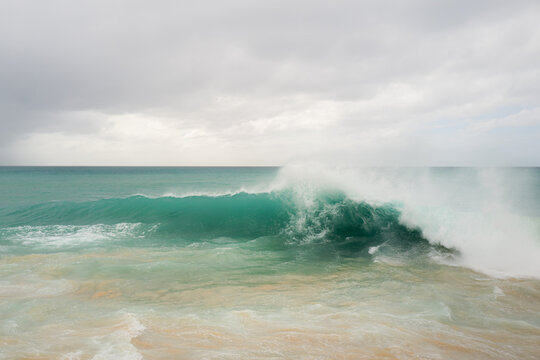 Crashing waves on the beach on Sint Maarten island in the Caribbean Sea.