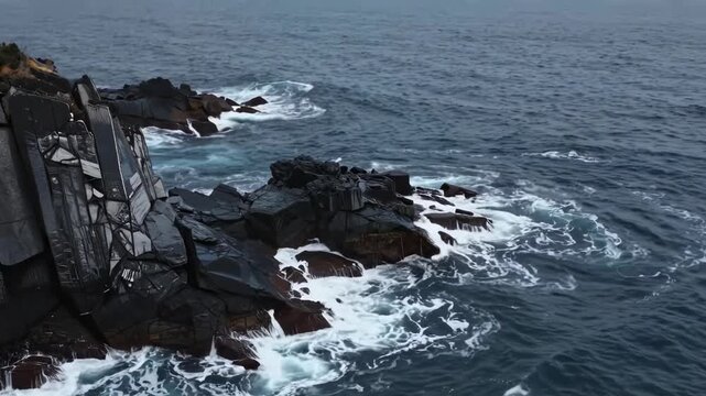 Turquoise Waves Crash Against Rugged Black Rocks Overlooking Ocean