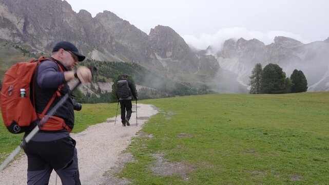 Tourists hiking in the Geisler National Park. Italy. Dolomites.