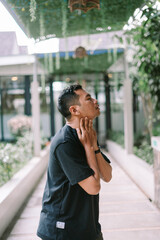 Fototapeta premium Young man suffering from neck pain touching neck with discomfort