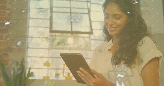 woman tapping tablet screen and showing tech data with power and recycling icons in loft office