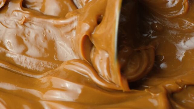 Dulce de leche on a spoon, thick boiled condensed milk