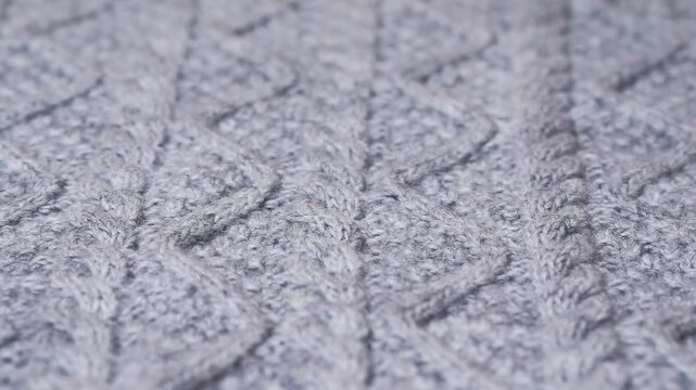 Knitted wool fabric texture background. Background of a gray knitted sweater with a yarn texture