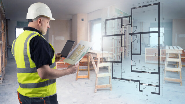 Construction supervision, Site inspection. Male engineer in helmet reviews floor plans and tablet data inside an unfinished building, checking layout accuracy and renovation progress.