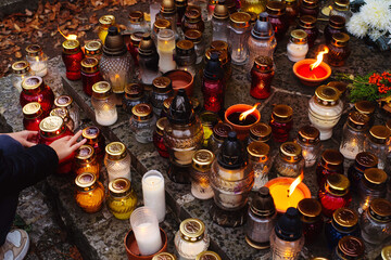 All Souls' Day. Numerous burning memorial candles on a stone gravestone