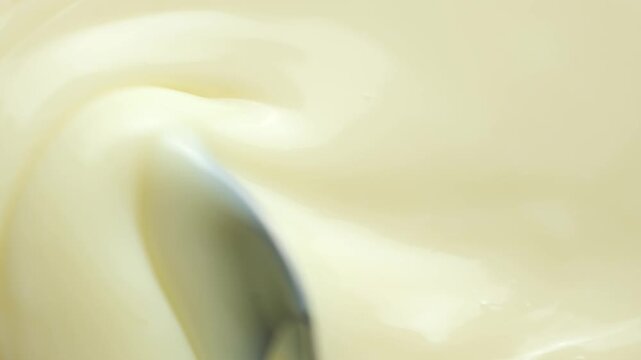 Spoon in a swirl of sweet condensed milk top view