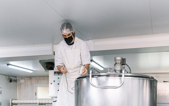 Worker checking temperature in food processing factory