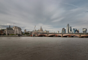 The timeless majesty of the London skyline unfolds across the River Thames, where the grand dome of St. Paul's Cathedral rises as a serene, neoclassical sentinel amidst a forest of contemporary