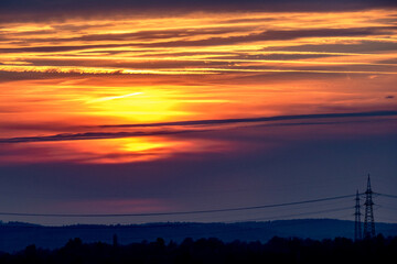 Obraz premium Sonnenuntergang und Hochspannungsmasten