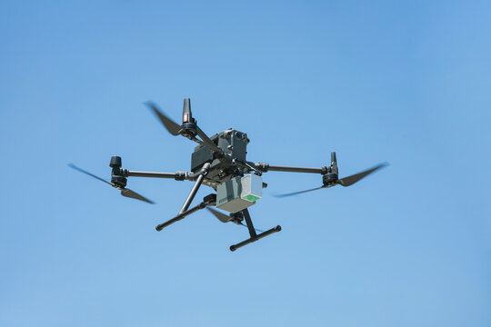 青空を飛行する産業用ドローンのクローズアップ 測量・点検DXとi-Constructionイメージ