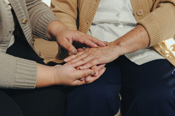 Obraz premium Younger and older hands touching, symbolizing support, empathy, and comfort for an aging individual. Generational care and connection