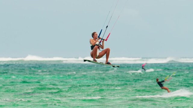 Sports woman kitesurfing in ocean in white bikini. Extreme summer sports