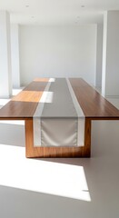 Fototapeta premium Elegant wooden dining table with a minimalist grey table runner in a bright, modern room with natural light casting shadows