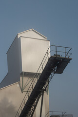 Naklejka premium Gravel plant with conveyor belt and industrial machinery in open landscape