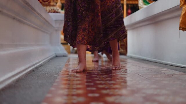 Barefoot woman walking in a traditional buddhist temple during a ceremony