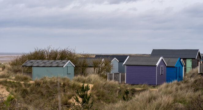 Traditional wooden beach huts in the sand dunes on Old Hunstanton beach on the North Norfolk Coast