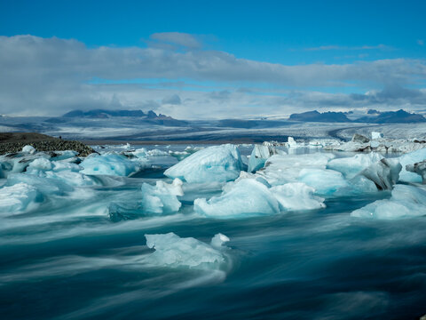 Icebergs flowing into the ocean along the narrow strait from Iceland's Jokulsarlon Glacier Lagoon, long exposure