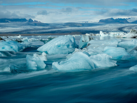 Icebergs flowing into the ocean along the narrow strait from Iceland's Jokulsarlon Glacier Lagoon, long exposure