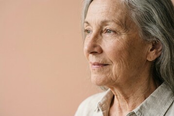 Obraz premium Senior woman with long grey hair and wrinkled skin facing right, embodying the beauty of aging and the experience of a mature individual looking towards the future