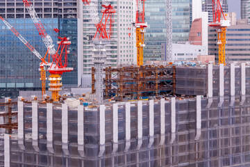 都市再開発により高層ビルが建設される現場 タワークレーンと鉄骨造のビル群 日本の都市風景 © Buppy