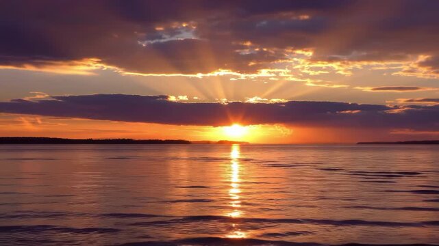 Vibrant sunset over a calm body of water with dramatic sun rays breaking through clouds